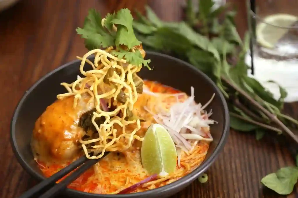 Bol de Khao Soi, soupe de nouilles au curry thaïlandaise, illustrant la gastronomie de la Thaïlande élue meilleure cuisine au monde.